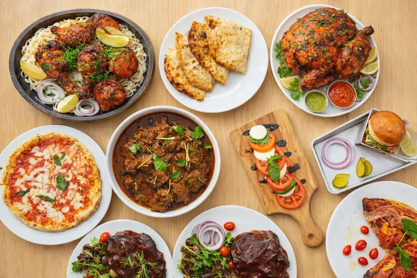 Spread of dishes at Chandigarh Curry House Calgary — tandoori chicken, naan, goat curry, pizza and burgers from the 915 6 Ave SW kitchen