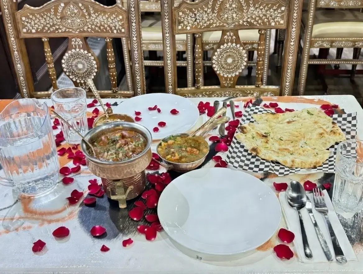 Indian catering by Chandigarh Curry House Calgary — table set with curry in a copper handi, naan and fresh soup for a private celebration
